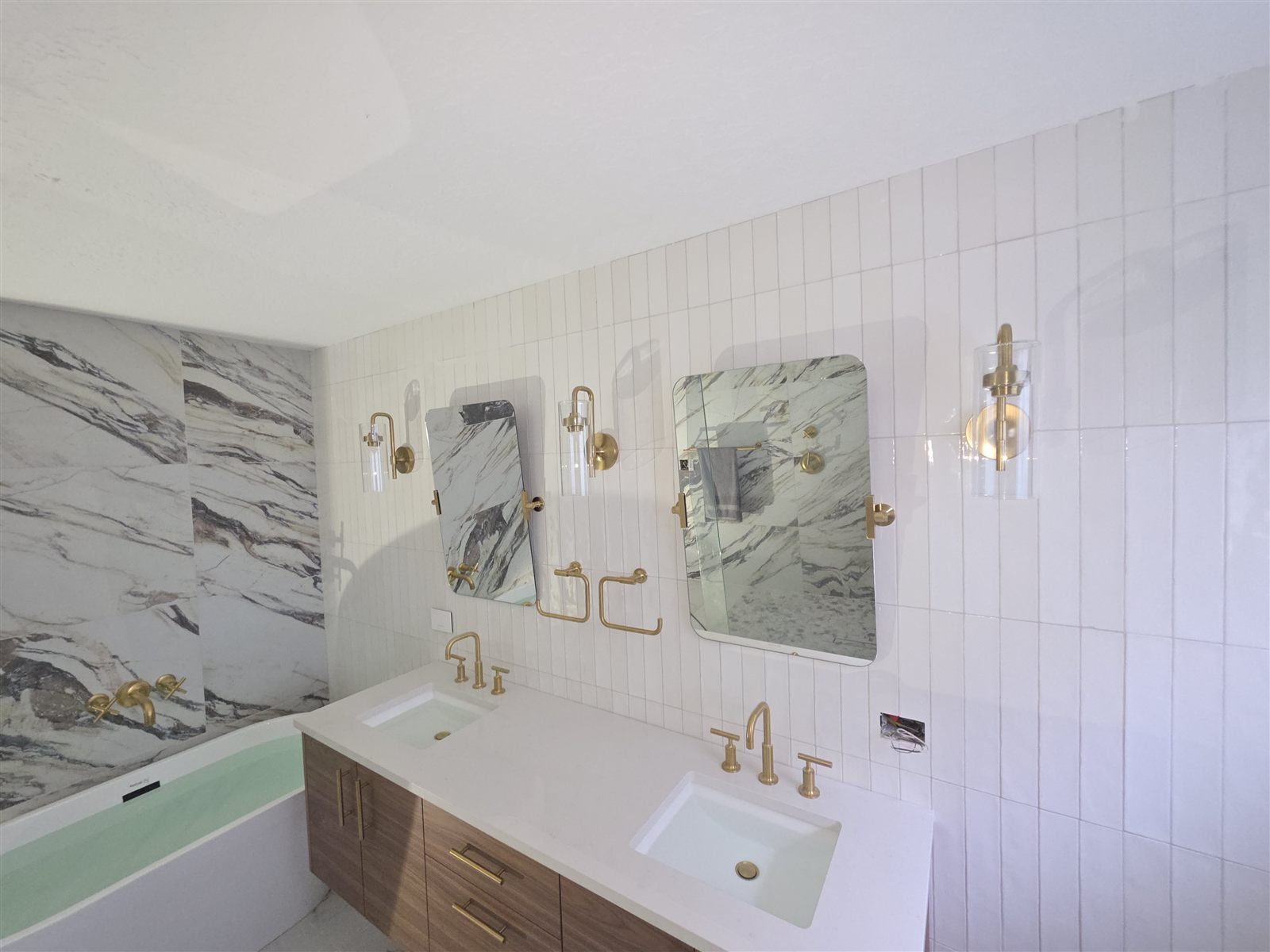 Bathroom vanity wall with vertical tile and gold sconces, Tampa Bay, FL