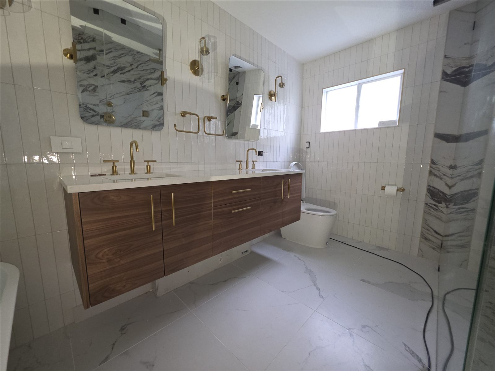 Bathroom renovation with marble tile and gold fixtures, Tampa Bay, FL
