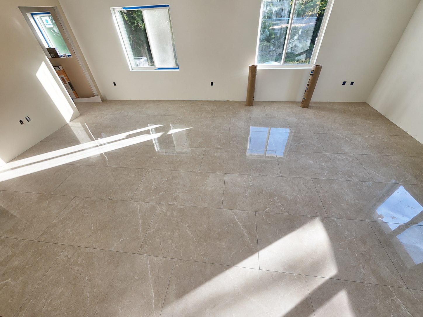 Large-format polished floor tile freshly installed in a bright open room, Tampa Bay, FL