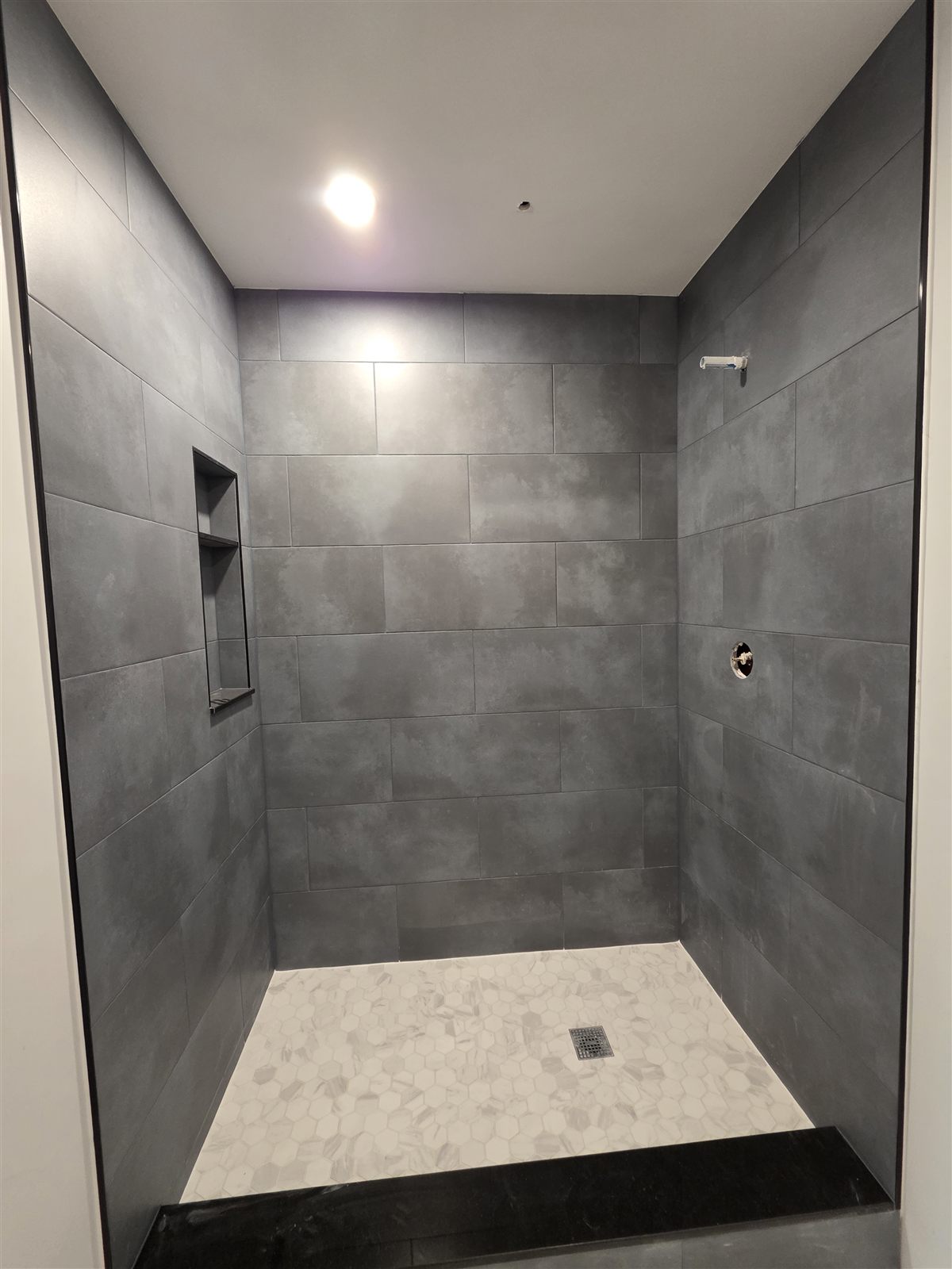 Large-format gray shower tile installation with black niche insert, Tampa Bay, FL